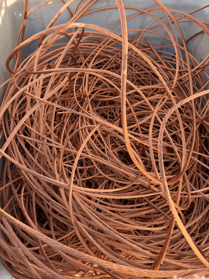Overhead view of a bin overflowing with bare bright copper wire coils