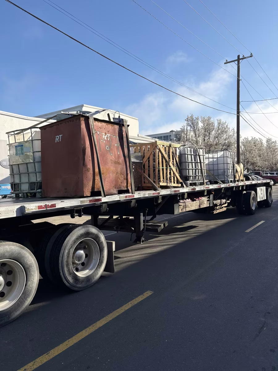 Flatbed semi loaded with IBC totes and pallets