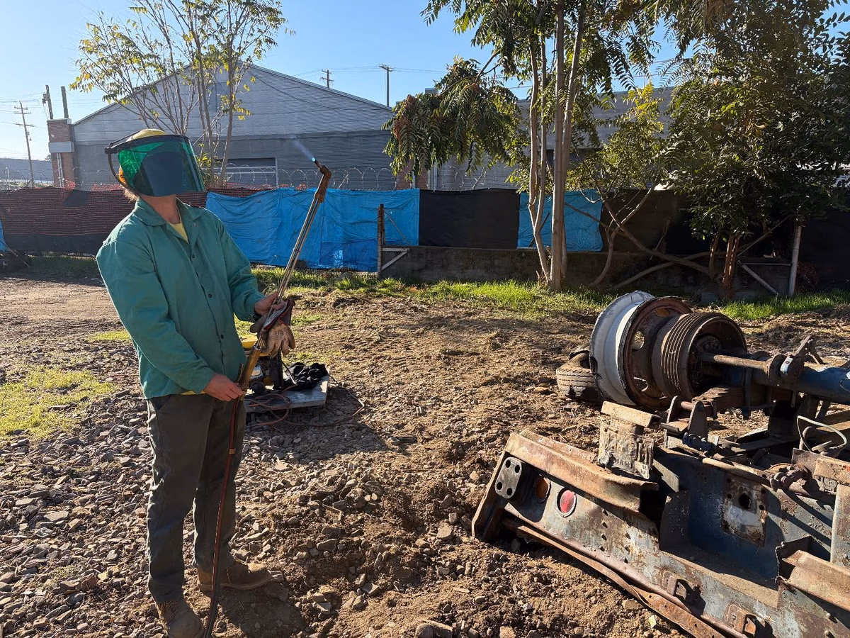 Haynes Industrial team member in a welding visor working with industrial equipment at a job site