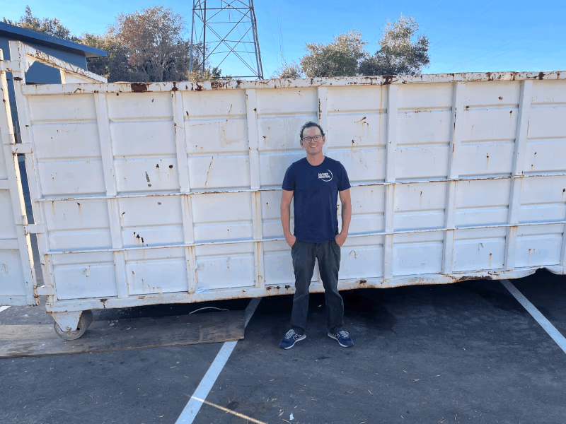 Jon Haynes, founder of Haynes Industrial, in front of a roll-off dumpster