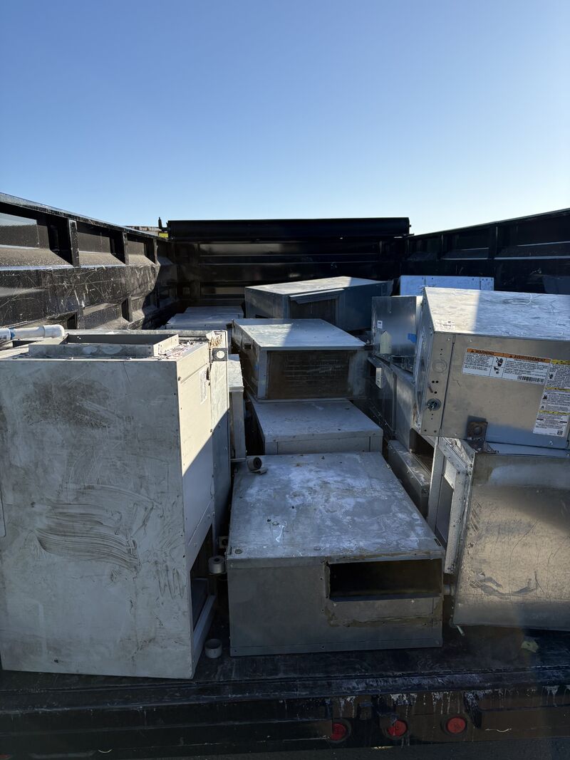 Dump trailer loaded with commercial rooftop HVAC units ready for recycling